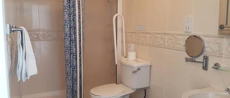 A bathroom with a shower, toilet, and sink.