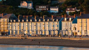 A seaside promenade with terraced houses and a beach. - Gwesty'r Marine Hotel & Spa (Aberystwyth)