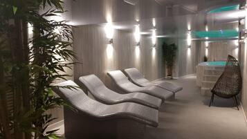 Relax in a serene spa area with lounge chairs and a hot tub.