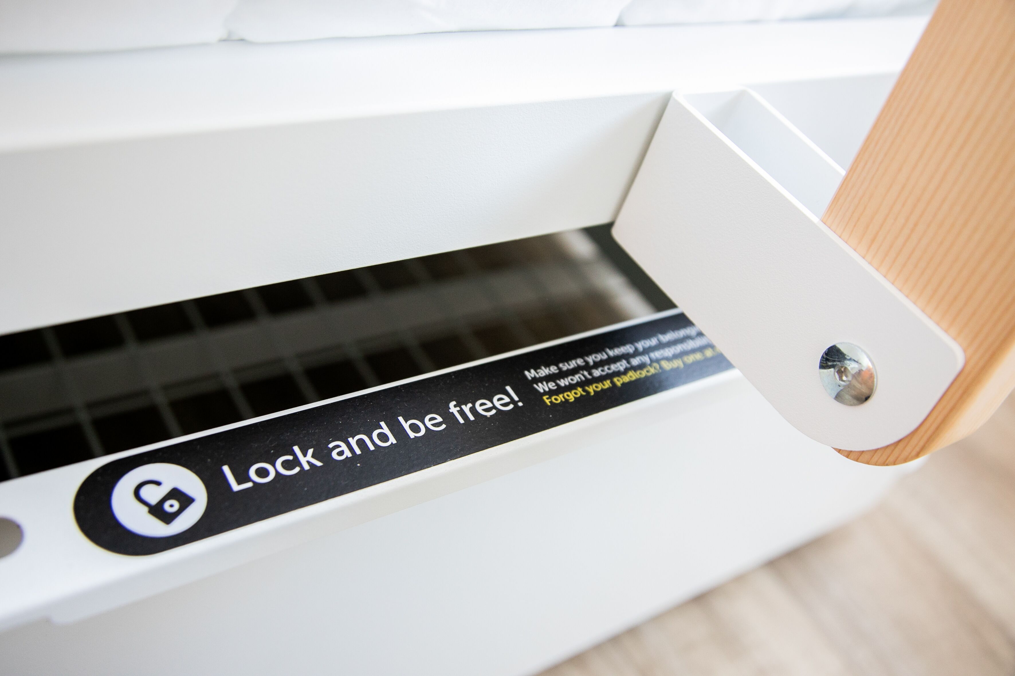 A close-up of a white door with a lock mechanism and a warning label that reads "Lock and be free!"