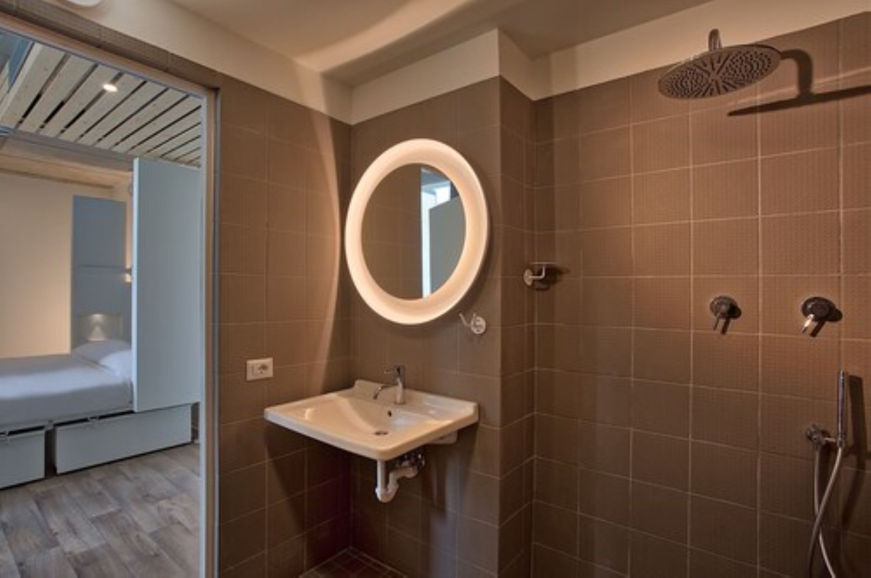 Un baño moderno con lavamanos integrado, un espejo y una ducha.