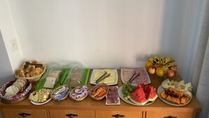 A breakfast buffet with various food items and a wall clock. - Pousada Habitue (Gramado)