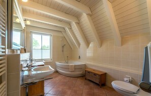 Un baño moderno con una bañera independiente, un lavamanos y un inodoro.