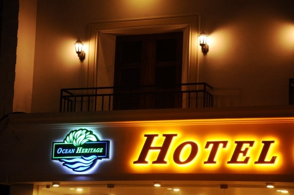 A hotel sign with "Ocean Heritage" and "HOTEL" illuminated.