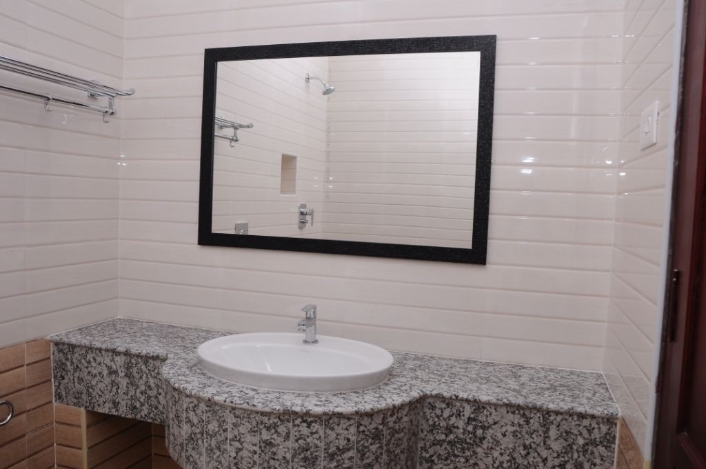 A bathroom with a white sink, a large mirror, and a shower.