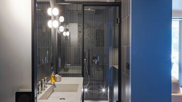 A modern bathroom with a dual sink vanity, a glass shower enclosure, and a visible towel rack.
