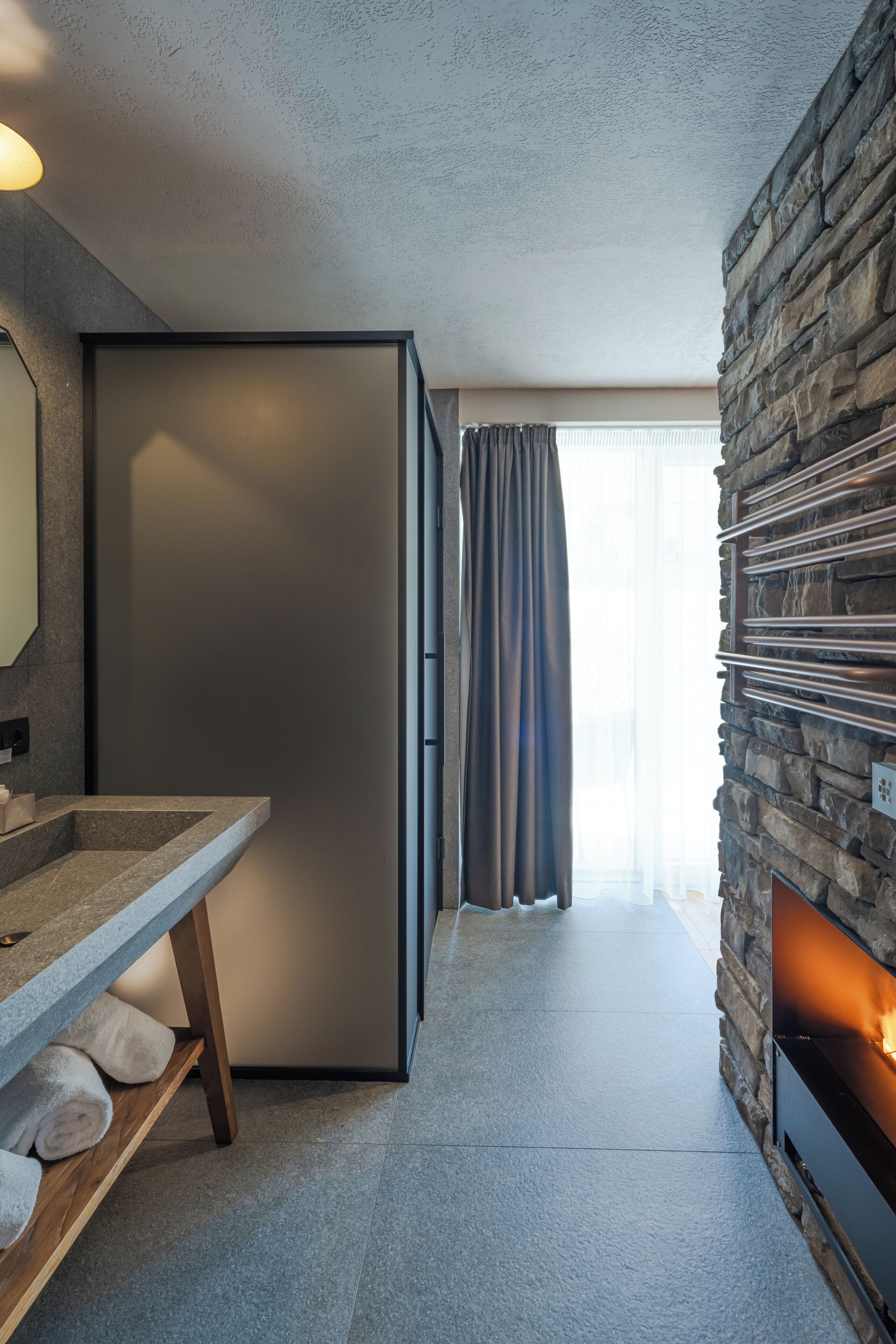 Eine moderne Küche mit Einbaukühlschrank, einer Wand mit Steinverkleidung und einem Kamin.