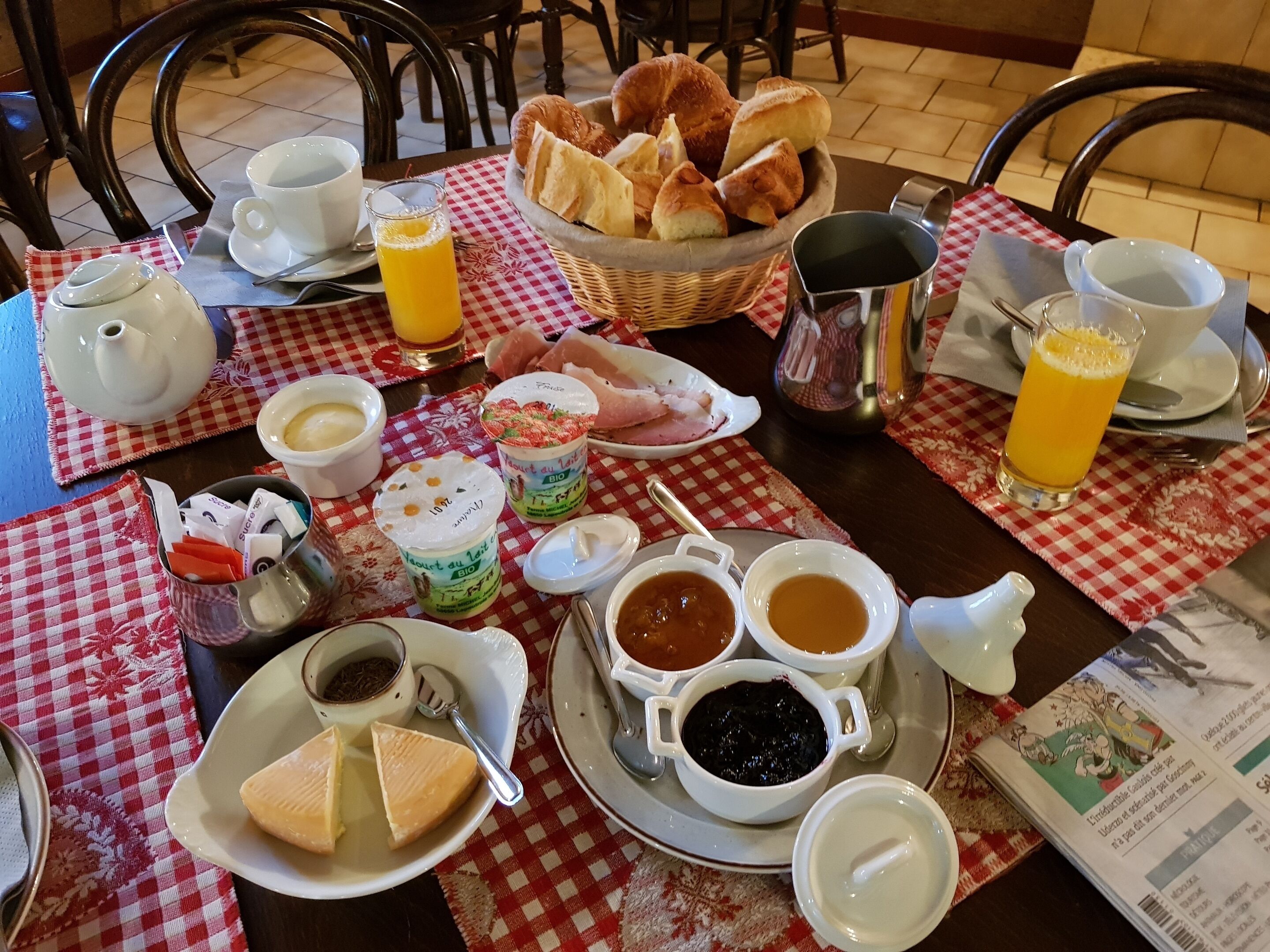 Una mesa de desayuno con diversos alimentos, como pan, pasteles y bebidas.