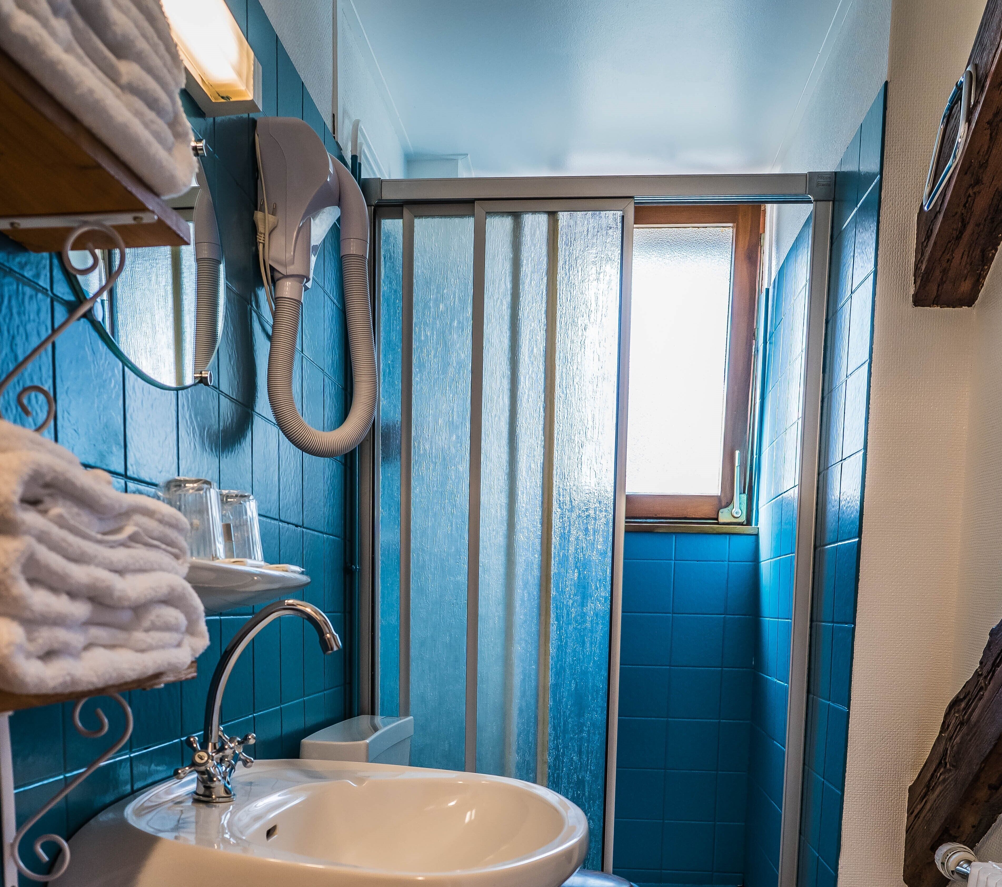 A bathroom with a sink, towel rack, and a window with a view.