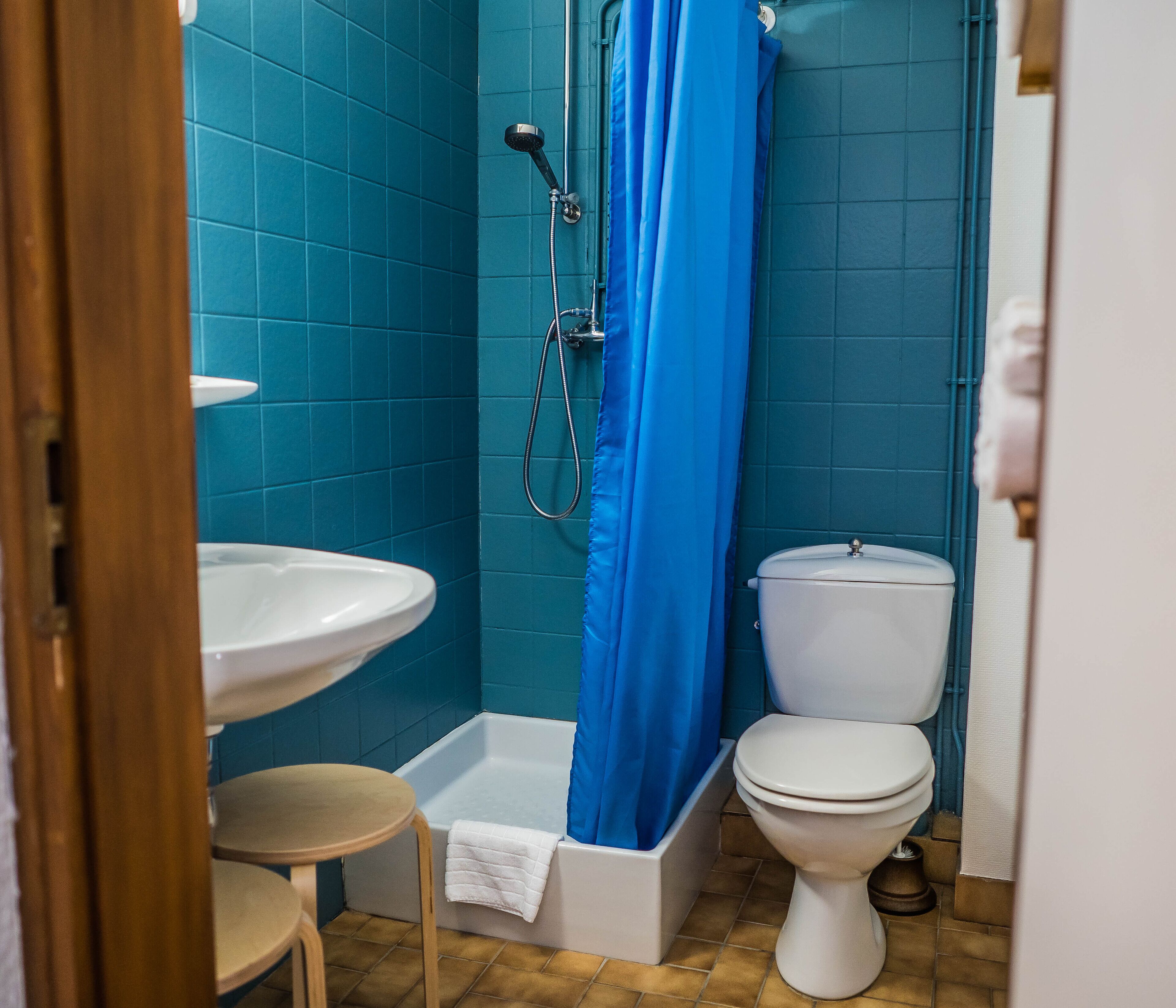 A bathroom with a shower, sink, and toilet.