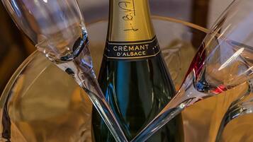 Una botella de champán en un cuenco de vidrio con dos copas de vino.
