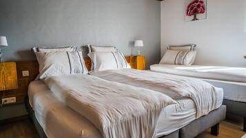 Driepersoonskamer | Bedden met traagschuimmatrassen, individueel gedecoreerd, een bureau