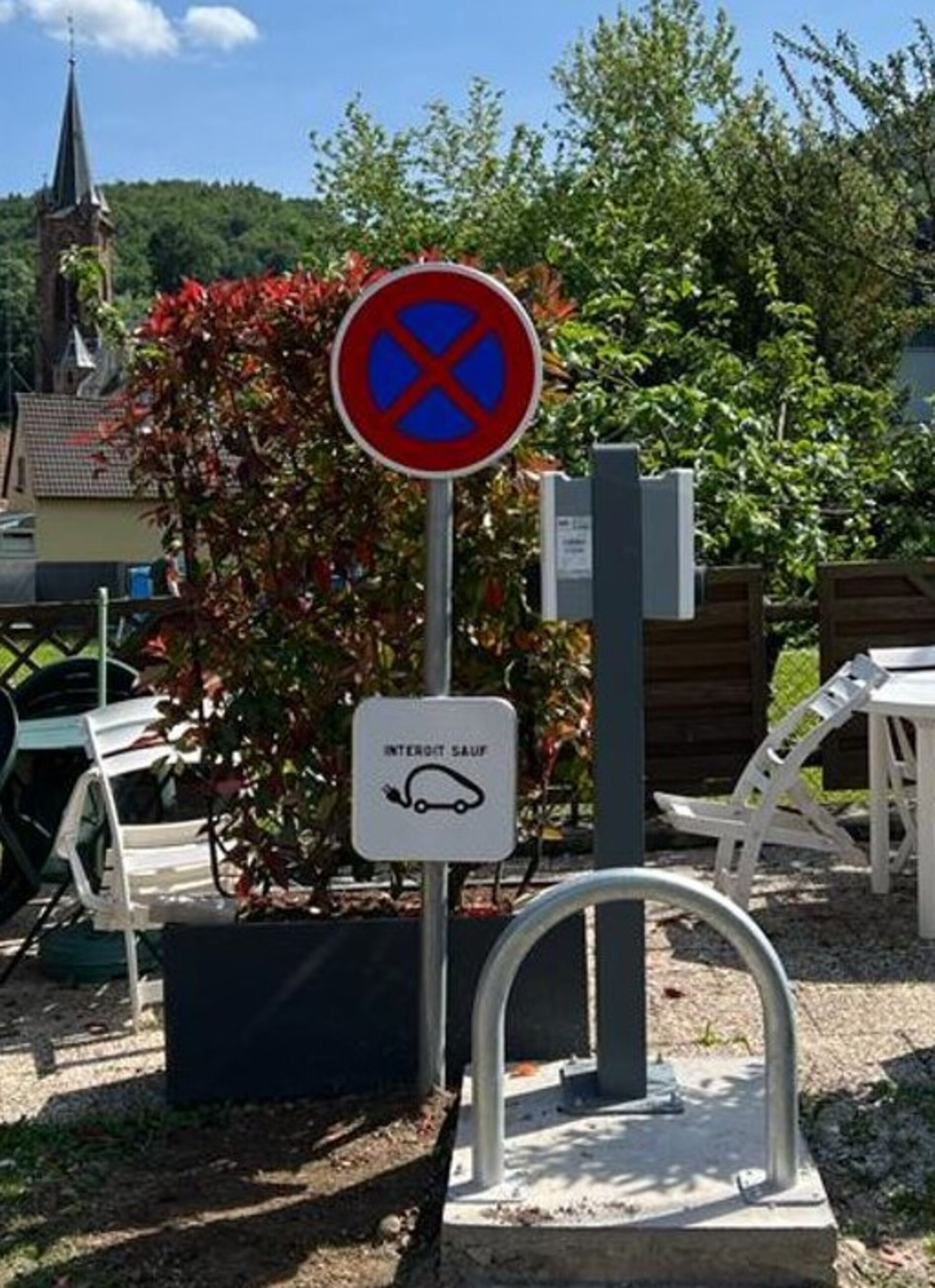 Een verboden parkeerbord met een symbool voor een oplaadstation.