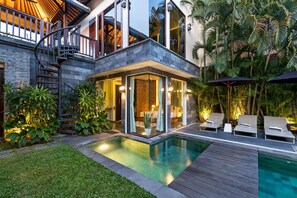 Une maison moderne dotée d’une piscine, d’un espace salon extérieur et d’une végétation luxuriante.