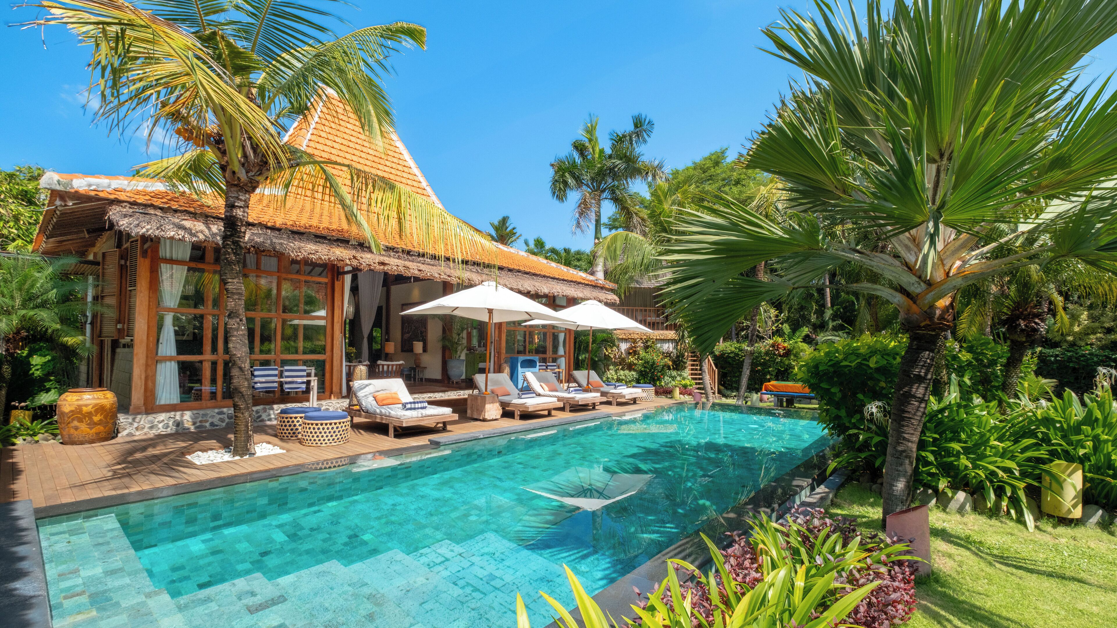 Una piscina al aire libre, sombrillas, tumbonas