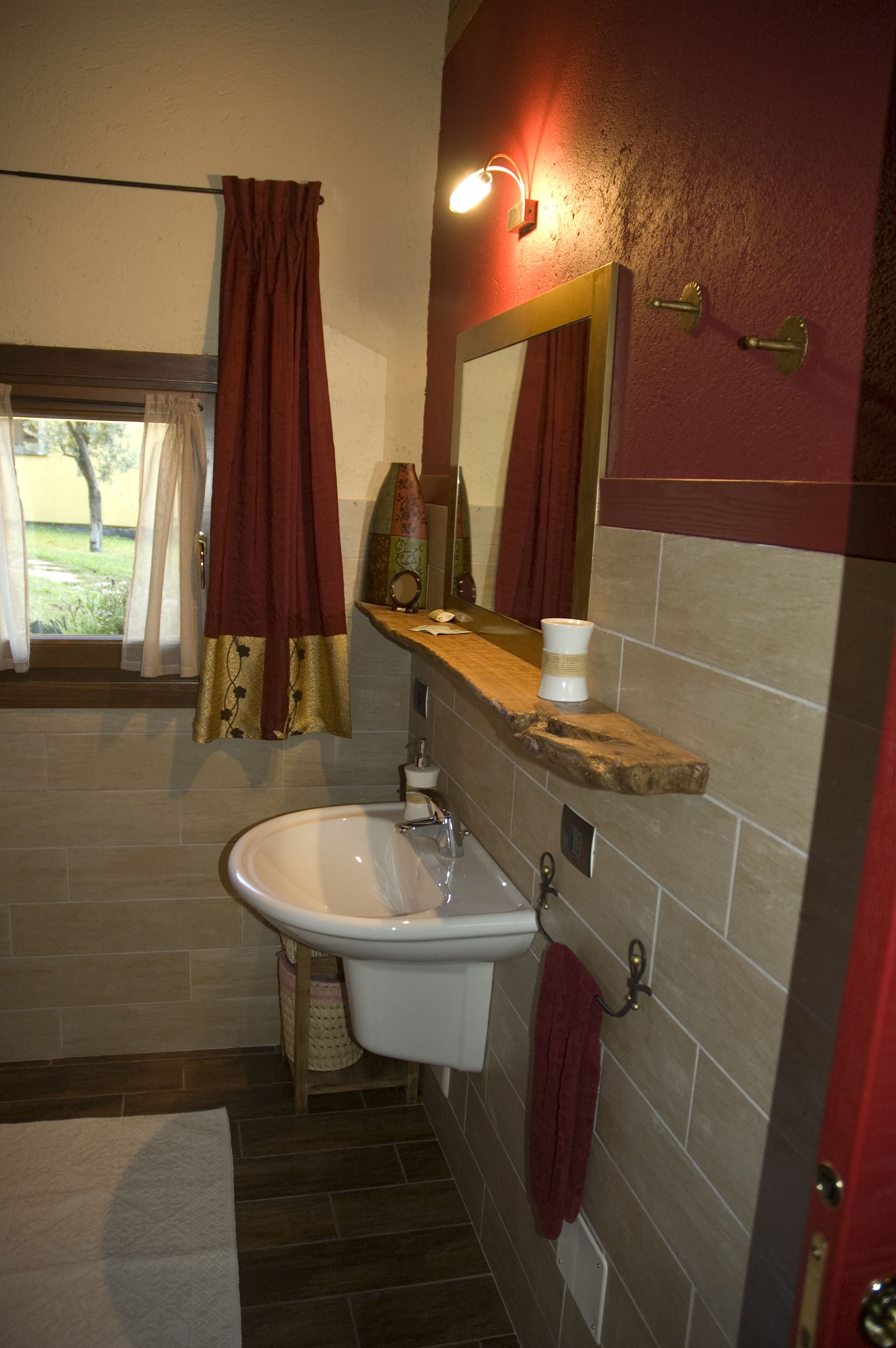 Un baño con lavamanos, espejo y toallero.