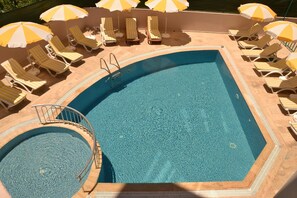 Piscina externa, guarda-sóis, espreguiçadeiras