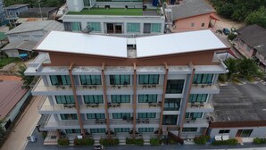 Un hotel de varios pisos con balcones, piscina y estacionamiento.