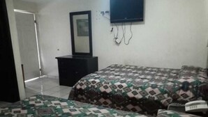 A bedroom with a bed, a dresser, a TV mounted on the wall, and a mirror. - Hotel Santander Inn & Suites (Ciudad Victoria)