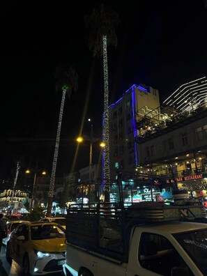 A nighttime urban street scene with illuminated buildings and vehicles. - Hawa Amman Hotel Downtown (Amman)