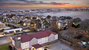 A waterfront hotel with multiple buildings, a marina, and a cityscape in the background. - Melrose @ Seabrook, BW Signature Collection (Seabrook)