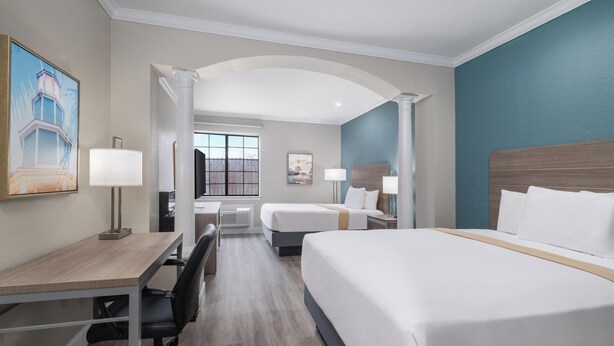 A hotel room with a desk, two beds, a large window, and a view of the outside. - Melrose @ Seabrook, BW Signature Collection (Seabrook)