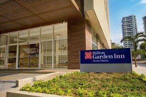 The exterior of the Hilton Garden Inn in Santa Marta, featuring a modern facade with large windows and a signboard. - Hilton Garden Inn Santa Marta (Santa Marta)