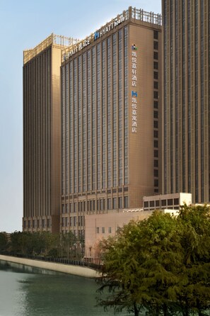 Een hoog hotelgebouw met meerdere verdiepingen en een opvallend bord bovenaan.