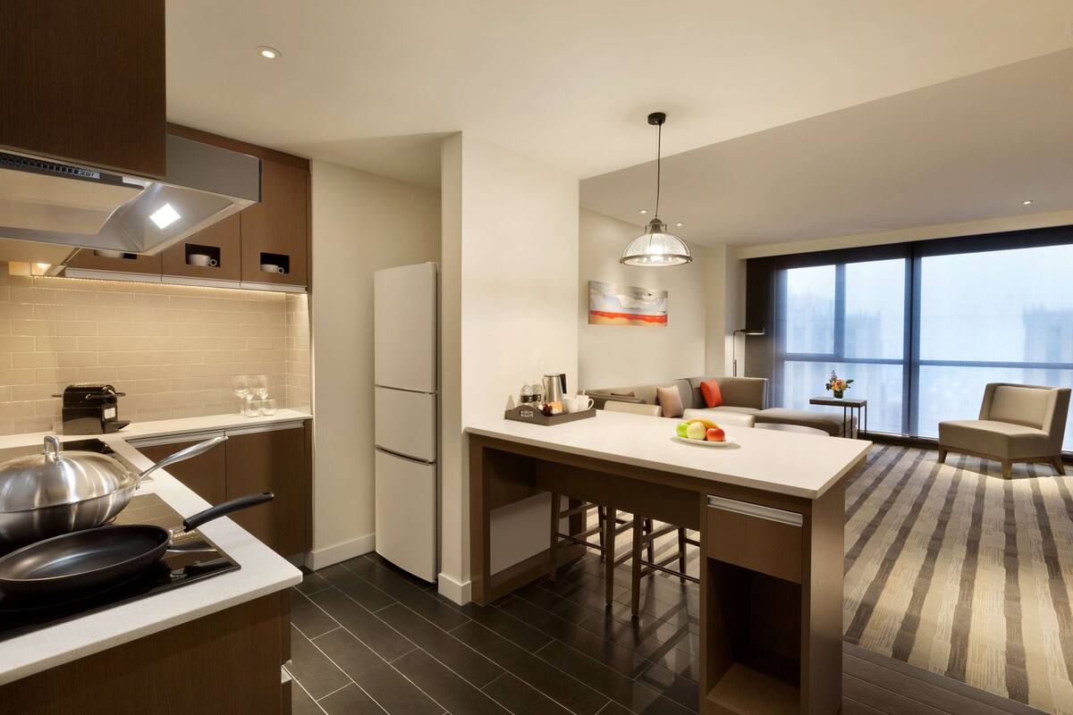 Een moderne keuken met een centraal eiland, een koelkast en een eetgedeelte met uitzicht.