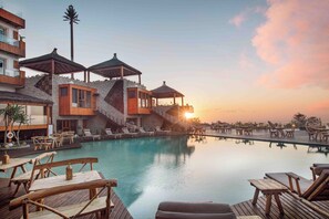 A resort with a swimming pool, wooden deck, and lounge chairs. - Chateau Eden El Rouh (Oualidia)