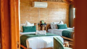 Een houten kamer met twee bedden, een houten plafond en een wandairconditioner.