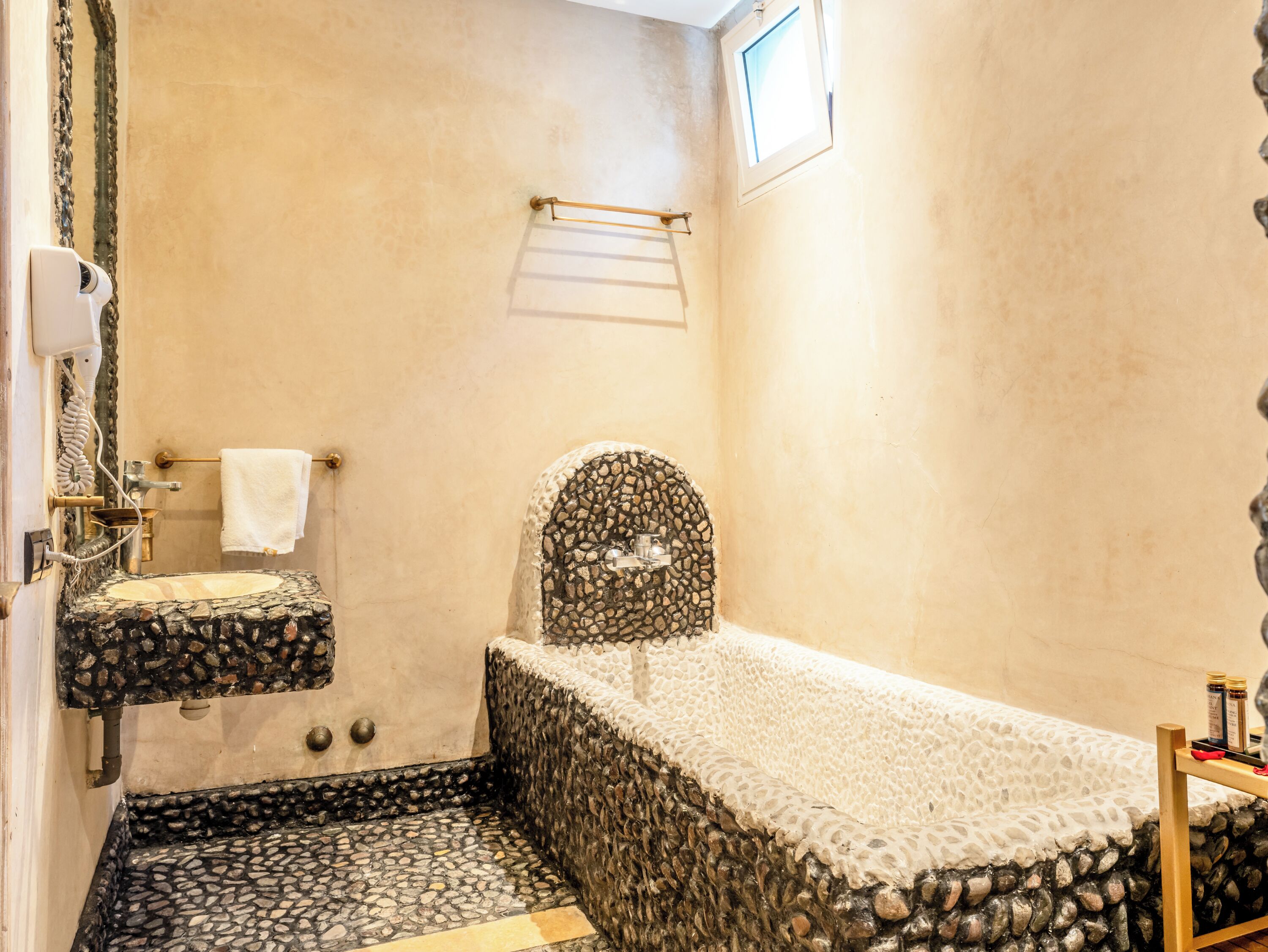 Un baño con lavamanos de piedra, bañera y ducha.