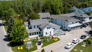 Ein mehrstöckiges Hotel mit Innenhof, Sitzgelegenheiten im Freien und einem Parkplatz.