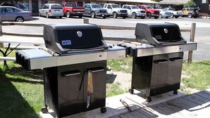 Two portable gas grills on a wooden deck. - Bunkhouse Motel (Guernsey)