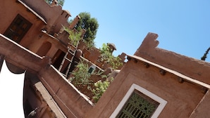 A traditional building with a window featuring decorative metal bars, a door, and a small balcony area. - Riad Cascades d'Ouzoud (Ait Taguella)