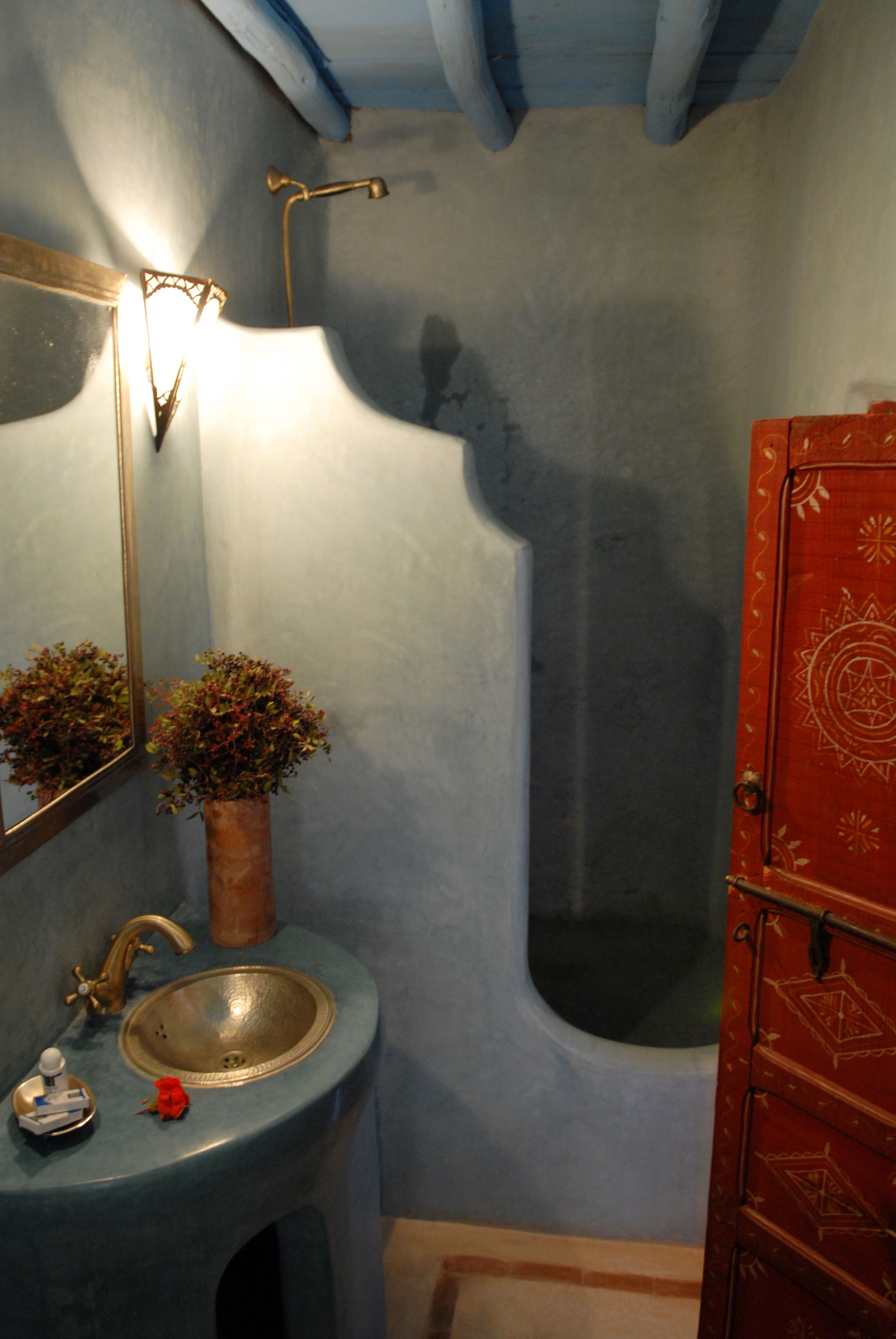 A bathroom with a sink, mirror, and a red cabinet.