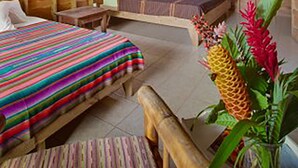 Una habitación de madera con dos camas, un banco y techo de madera.