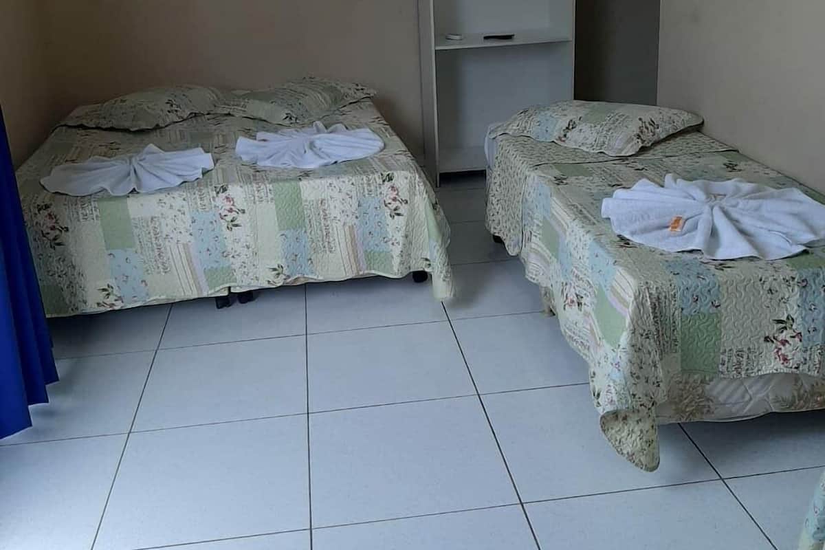 Una habitación con dos camas, cada una con ropa de cama y toallas de estampado floral dispuestas sobre ellas.