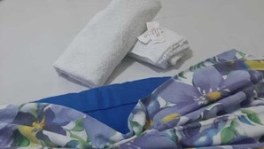 Een bed met witte kussens en een opgevouwen witte handdoek.