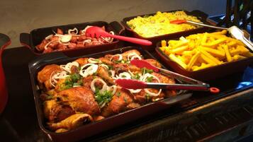 Un buffet proposant du poulet rôti, des frites et du riz.