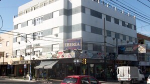 Un hotel de varios pisos con un llamativo letrero 'IBERIA', que presenta una fachada moderna con ventanas grandes y balcones.