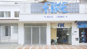 A hotel with a large sign reading "FIKI HOTEL LOUNGE" and a visible entrance with a glass door and a small plant inside. - Hotel Fike (Bucaramanga)