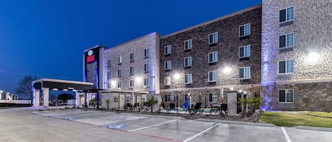 Vista frontal de la propiedad por la tarde o noche