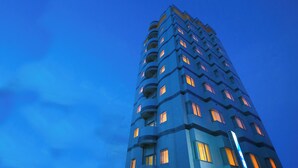 Een hoog gebouw met meerdere balkons en ramen, vermoedelijk een hotel of appartementencomplex.