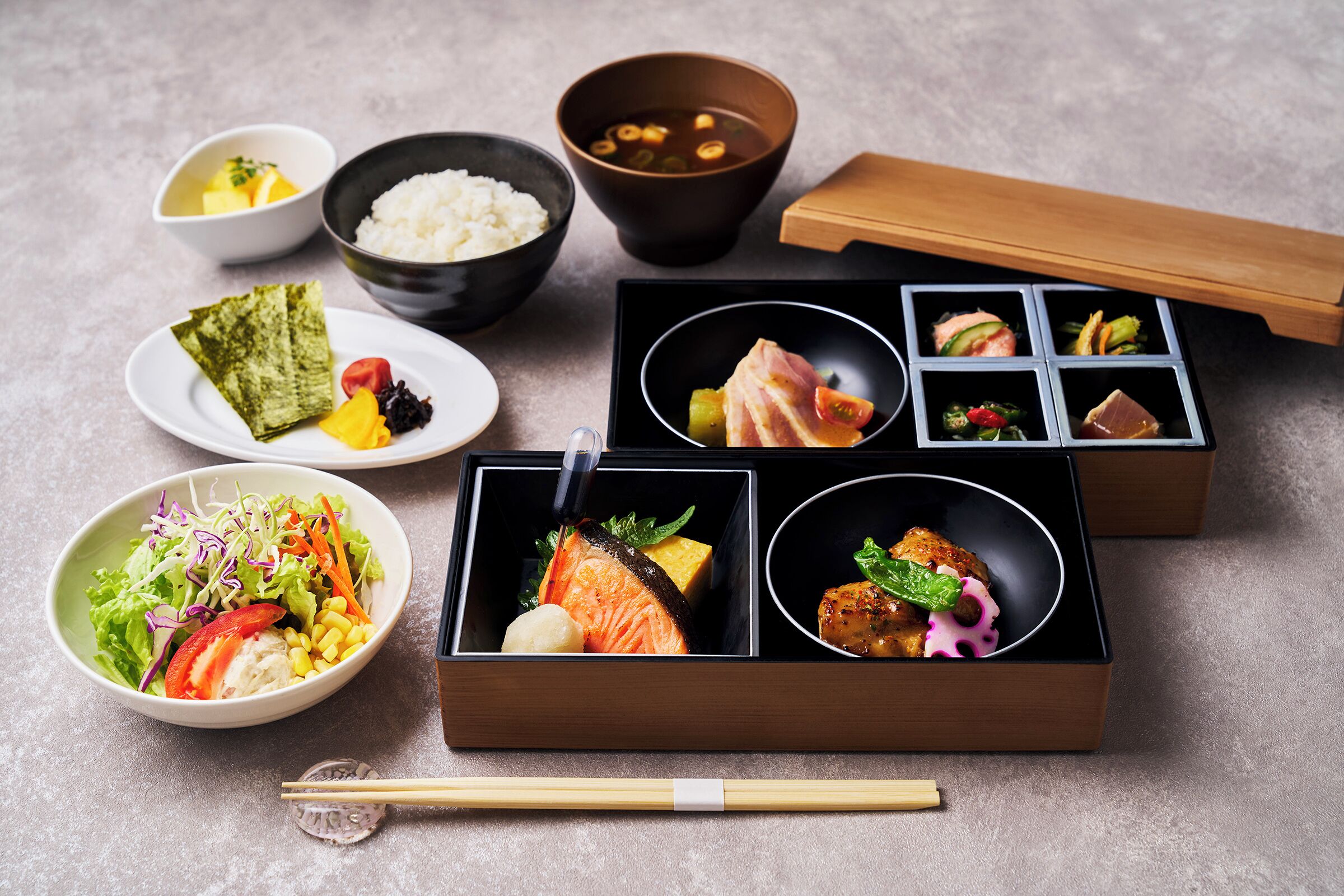 A variety of Japanese dishes arranged on a table, including rice, soup, and different types of sashimi.