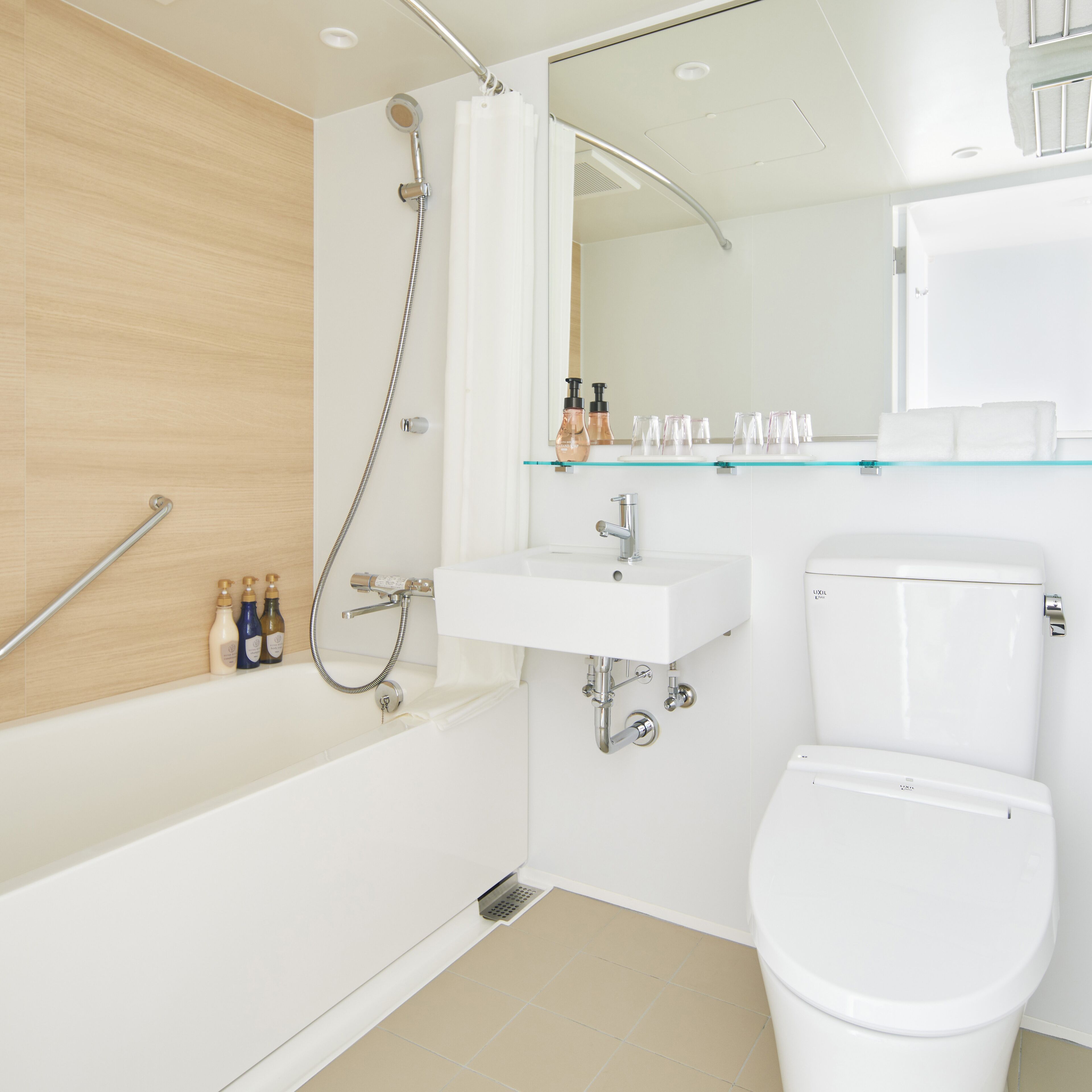 A modern bathroom with a bathtub, shower, sink, and toilet.