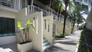 Un bâtiment moderne au design épuré et minimaliste, caractérisé par une série de marches menant à un espace abrité doté de rampes blanches.