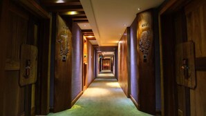 A long, narrow hallway with wooden walls and doors, leading to a room at the end. - HuanHuaHongTai hotel (Chengdu)