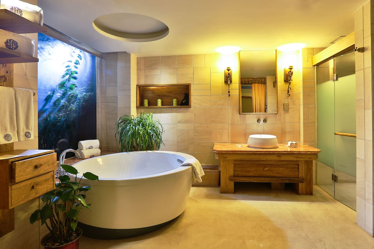A modern bathroom with a freestanding bathtub, wooden vanity, and a large mirror.