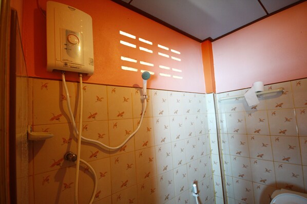 A bathroom with a shower, toilet, and a water heater.